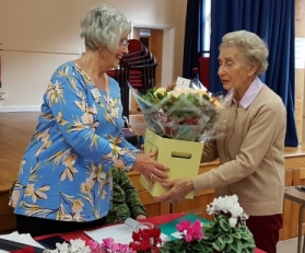 President presenting flowers to a member who has been on the Committee for many years